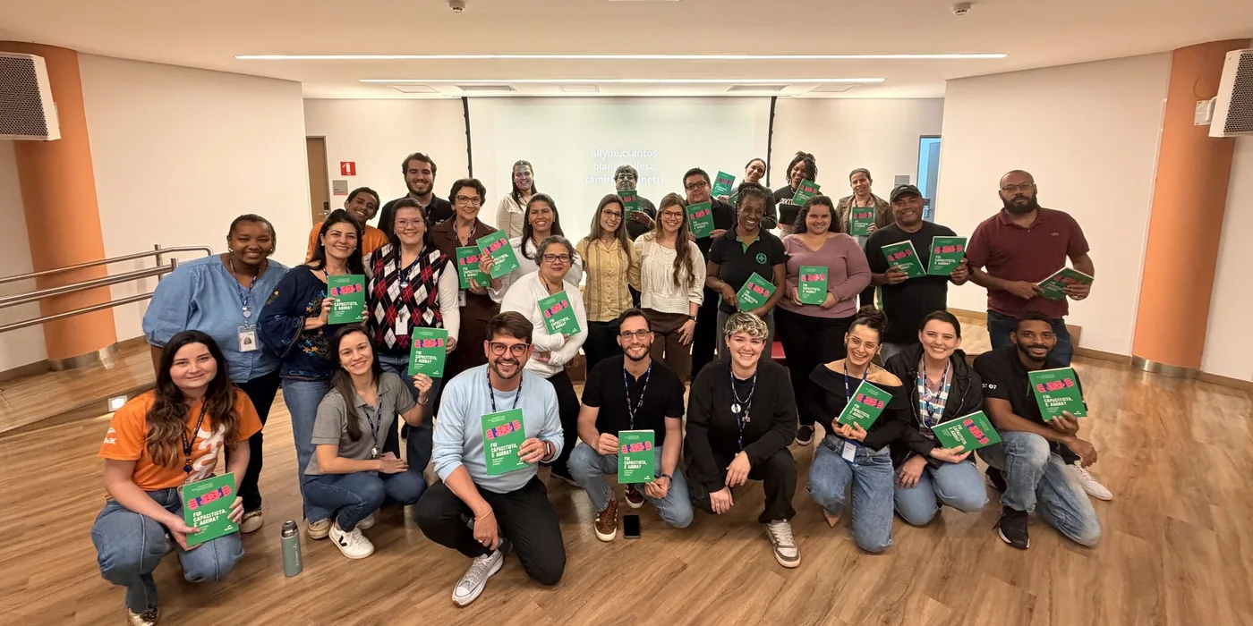 Foto de grupo com cerca de trinta participantes de uma formação, cada um segurando um exemplar do livro Fui capacitista, e agora?